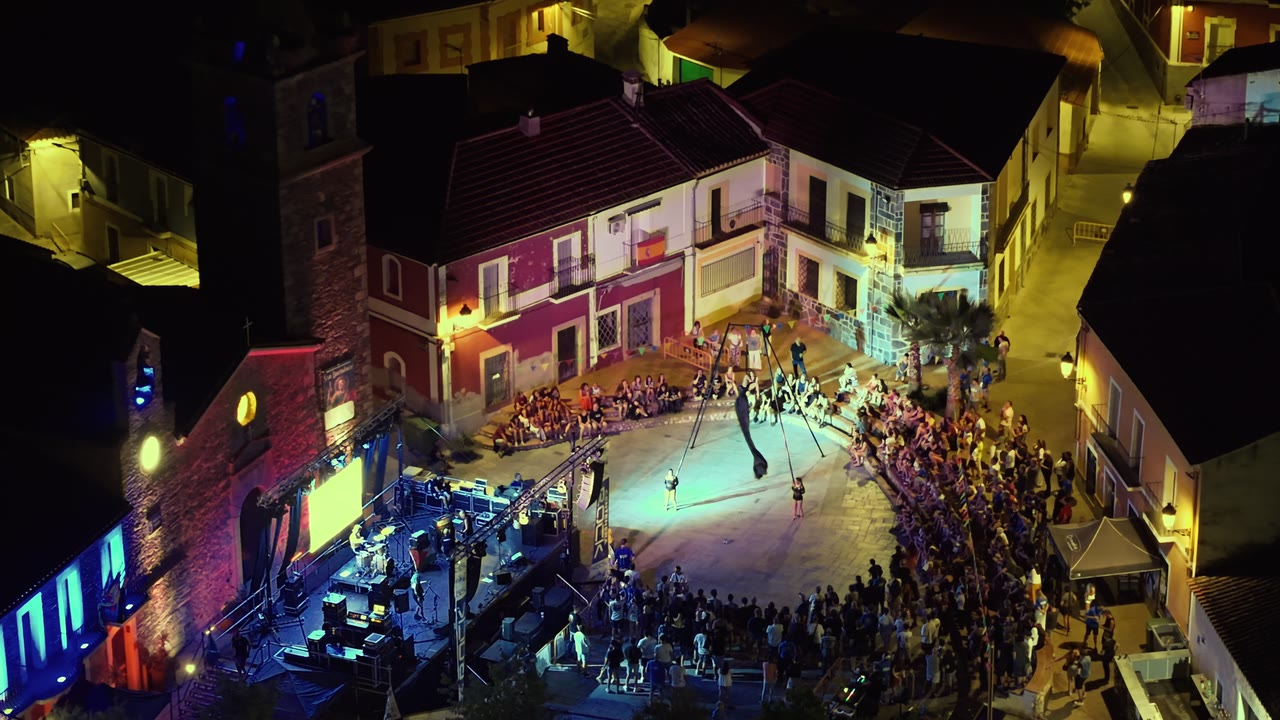 Plaza de un pueblo de noche durante un evento, vista desde el dron en plano general
